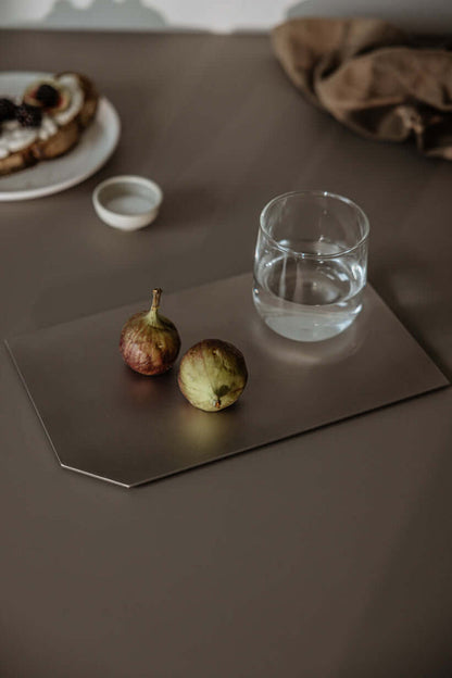 Dekotablett mit frischen Feigen und einem Glas Wasser auf einem eleganten Tisch