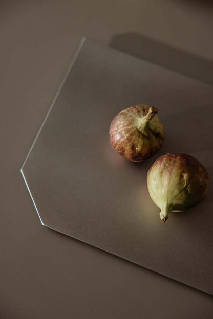 Dekotablett mit zwei frischen Feigen auf einem eleganten, flachen Edelstahl-Design.