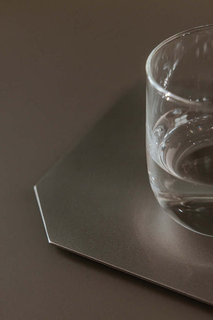 Dekotablett mit Glas Wasser, modernes Design aus gestrahltem Edelstahl, flaches Accessoire für Zuhause.