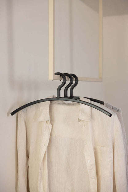 Kleiderbügel FAY im minimalistischen Design mit beiger Bluse im Hintergrund, ideal zum Schutz empfindlicher Kleidung.