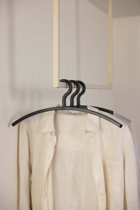 Kleiderbügel FAY im minimalistischen Design mit beiger Bluse im Hintergrund, ideal zum Schutz empfindlicher Kleidung.