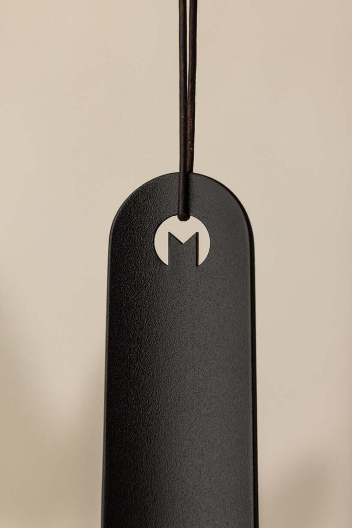 Schuhlöffel TILO aus hochwertigem Metall mit minimalistischer Form und Logo-Design, ideal für moderne Interieurs.