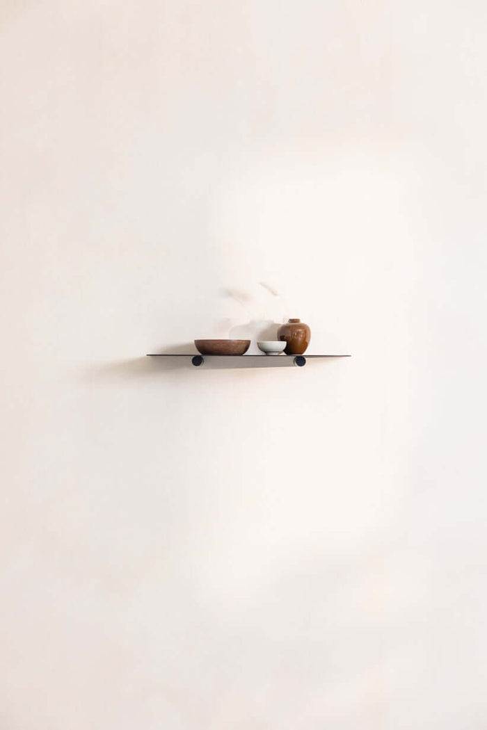 Wandregal LENN mit dekorativen Schalen auf minimalistischem Metallregal an einer weißen Wand.