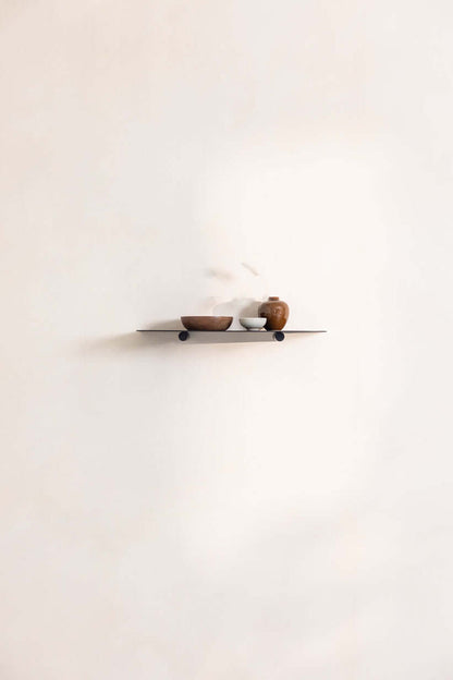 Wandregal LENN mit dekorativen Schalen auf minimalistischem Metallregal an einer weißen Wand.