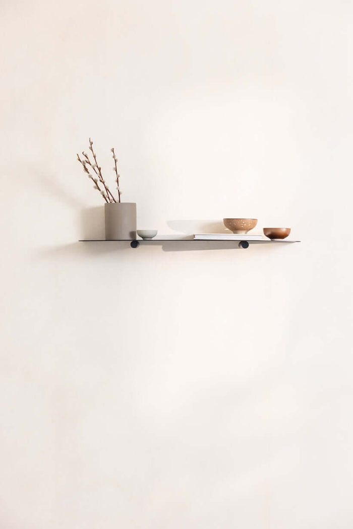 Wandregal LENN aus Metall mit minimalistischen Design, dekoriert mit Vasen und Schalen.