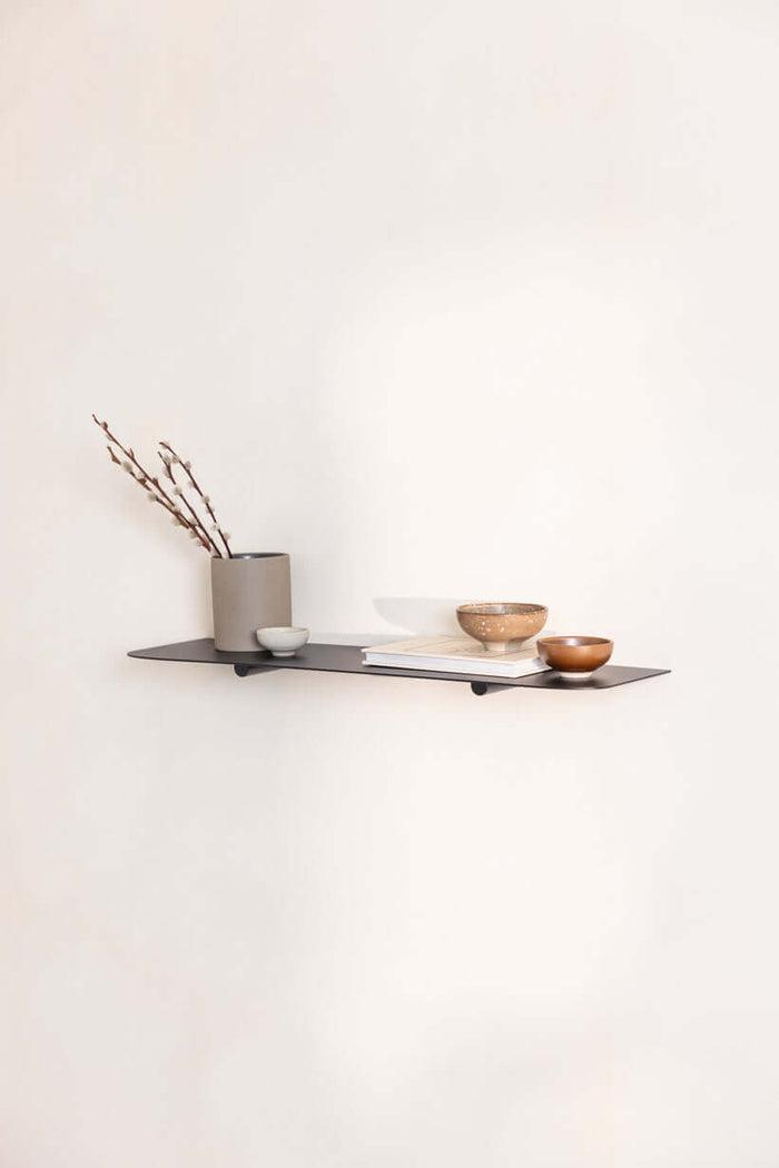 Wandregal LENN mit modernen Dekorationsobjekten auf einem minimalistischen Metallregal